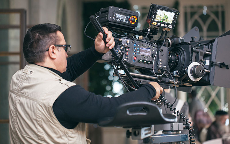 Portrait of contemporary young woman holding FOLLOW word while filming video for beauty and lifestyle channel, copy space